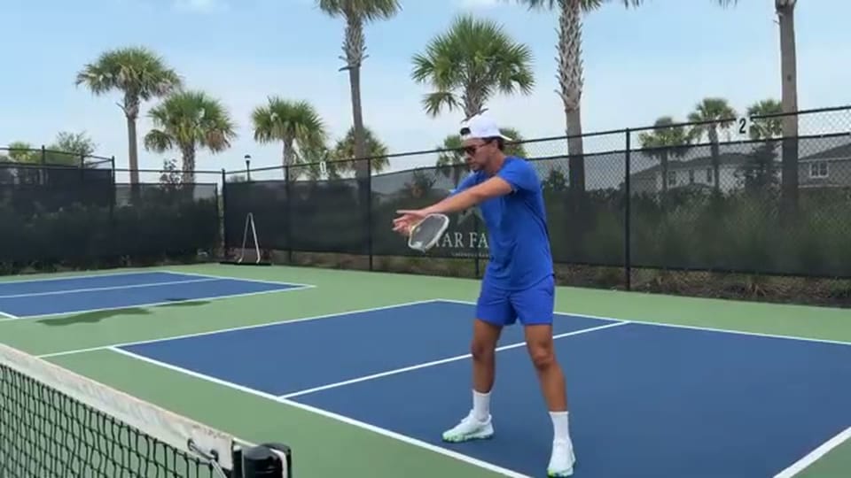 Universal Rackets 教練在匹克球非截擊線旁示範球拍放在身體前方的短擋截擊準備動作